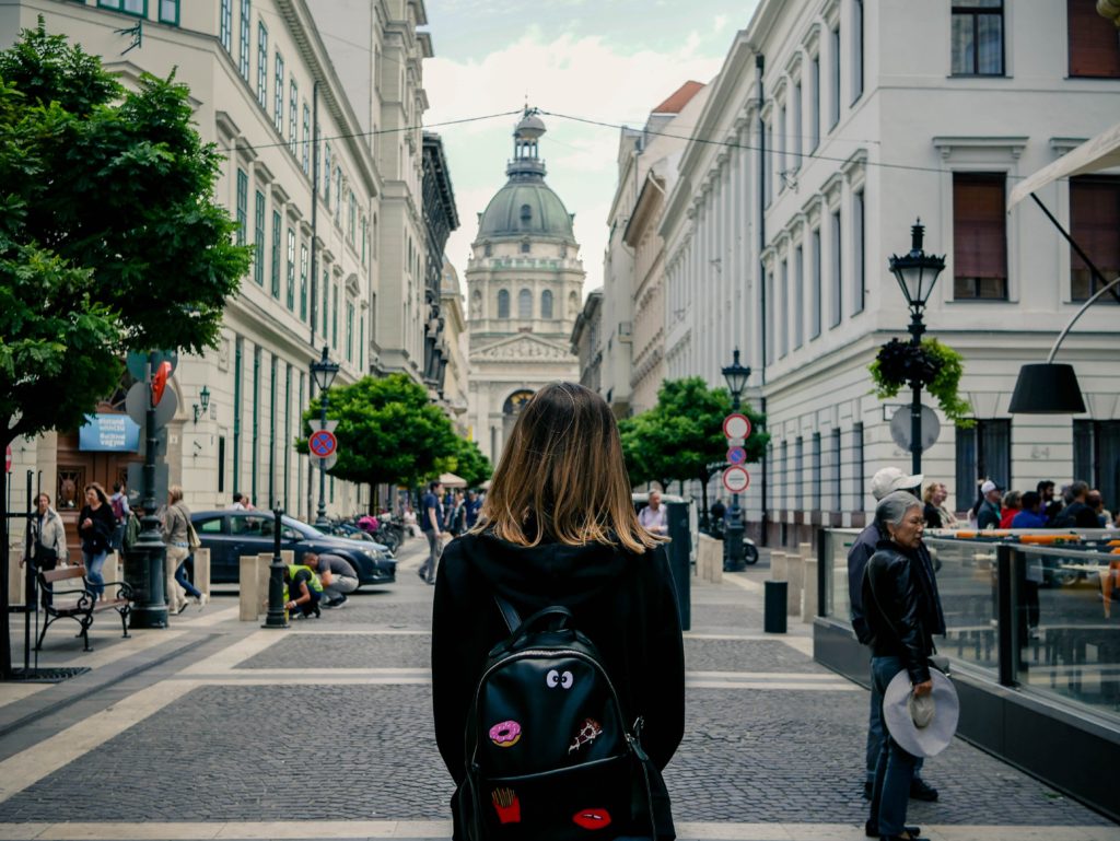  woman carrying backpack in a street